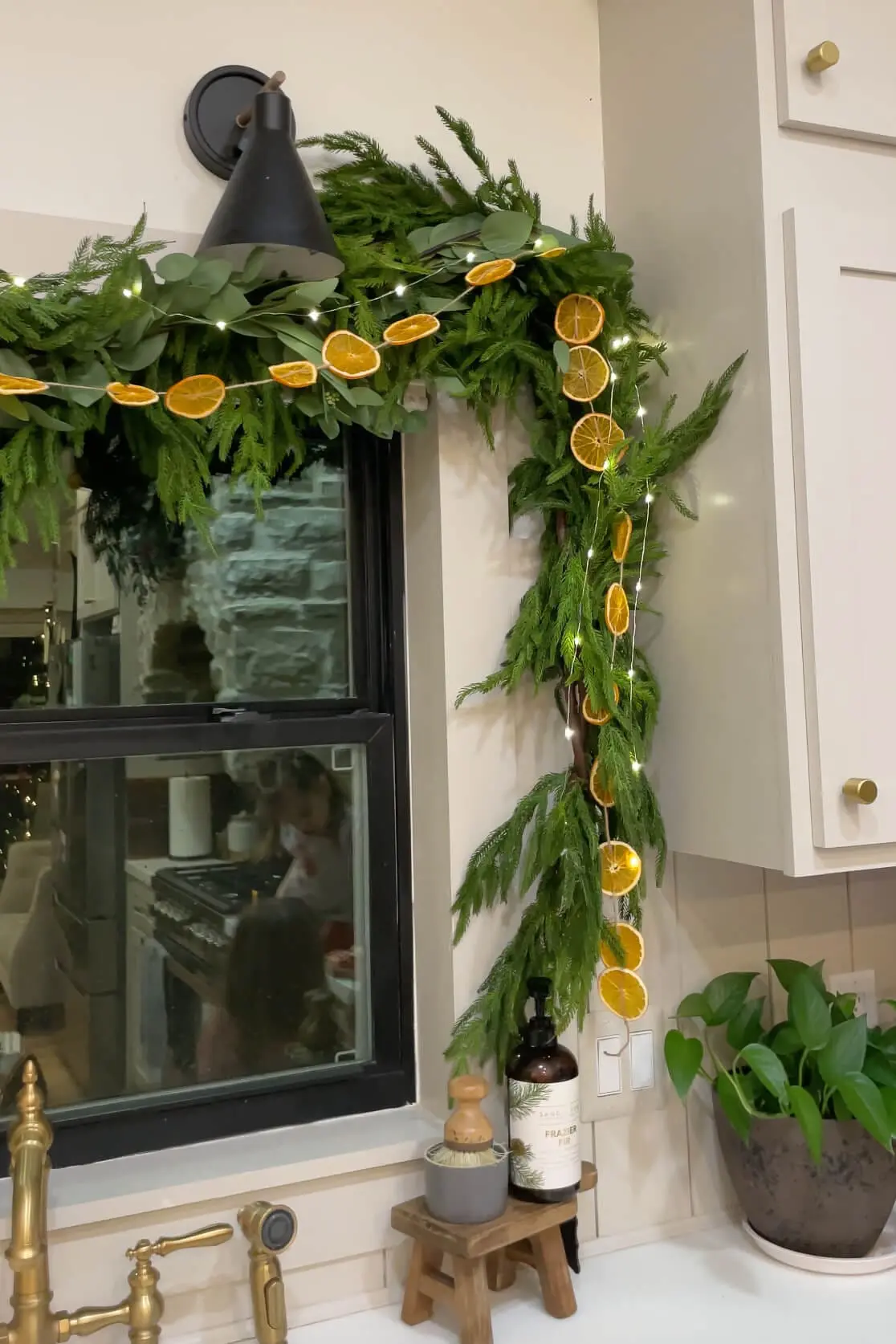 Adding battery operated Christmas lights to gorgeous pine garland.